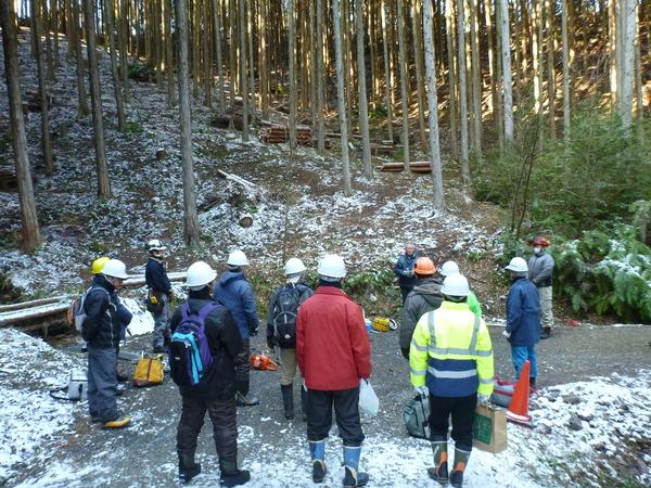 山の中でヘルメットを被った受講生が説明を受けている写真